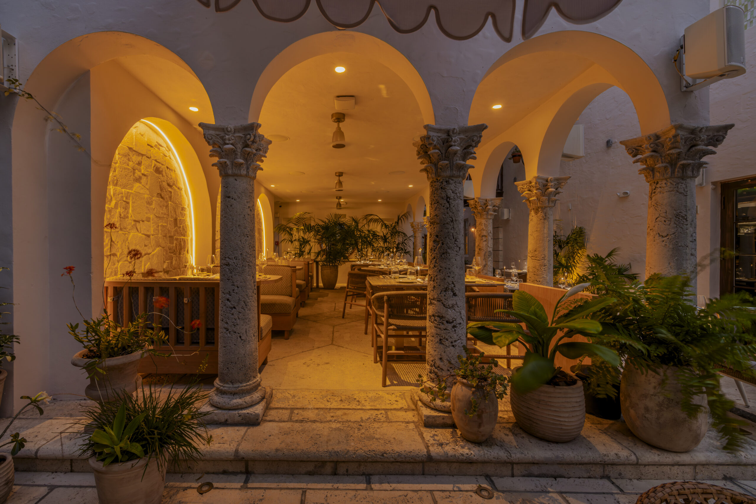 Mediterranean Revival style architecture with stone arches at Donatella Restaurant, a quiet dinner oasis near Ocean Drive
